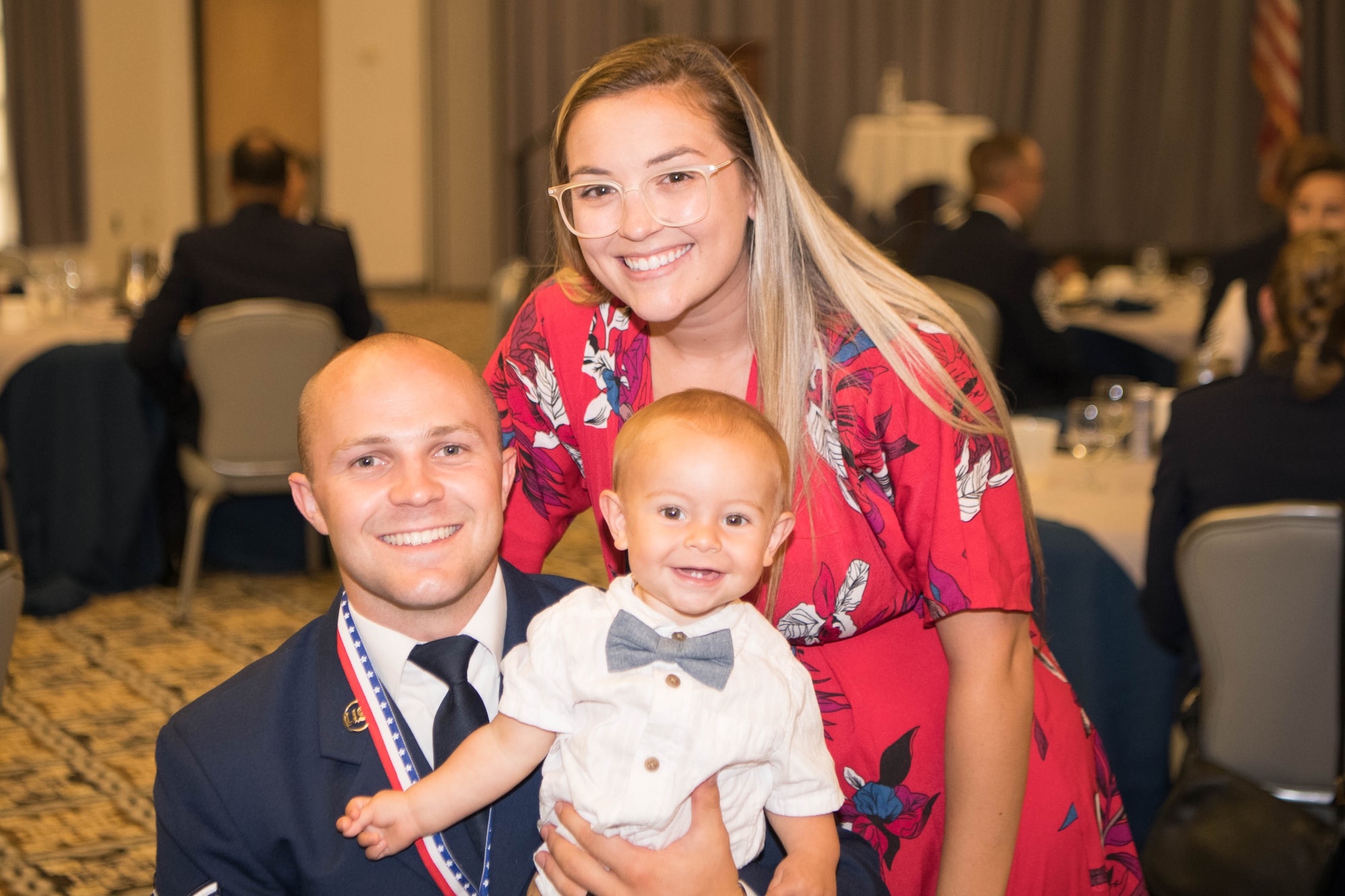 Senior Airman Austin Dean, 436th Aircraft Maintenance Squadron crew chief; his wife Ashley; and son Weston pose for a photo during the Staff Sgt. Julio Alonso Airman Leadership School, Class 21-F, dinner and graduation ceremony held at The Landings on Dover Air Force Base, Delaware, July 22, 2021. Twenty-nine Airmen graduated at the first post-COVID-19 dinner and graduation ceremony. (U.S. Air Force photo by Mauricio Campino)