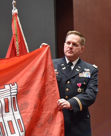 Lt. Col. Hugh Darville, recieves a U.S. Army Corps of Engineers flag signed by the U.S. Army Engineering and Support Center, Huntsville work force during his retirement ceremony at Sparkman Center's Bob Jones Auditorium July 20. Darville served with the U.S. Army Engineering and Support Center, Huntsville since 2017 as deputy commander and interim commander.