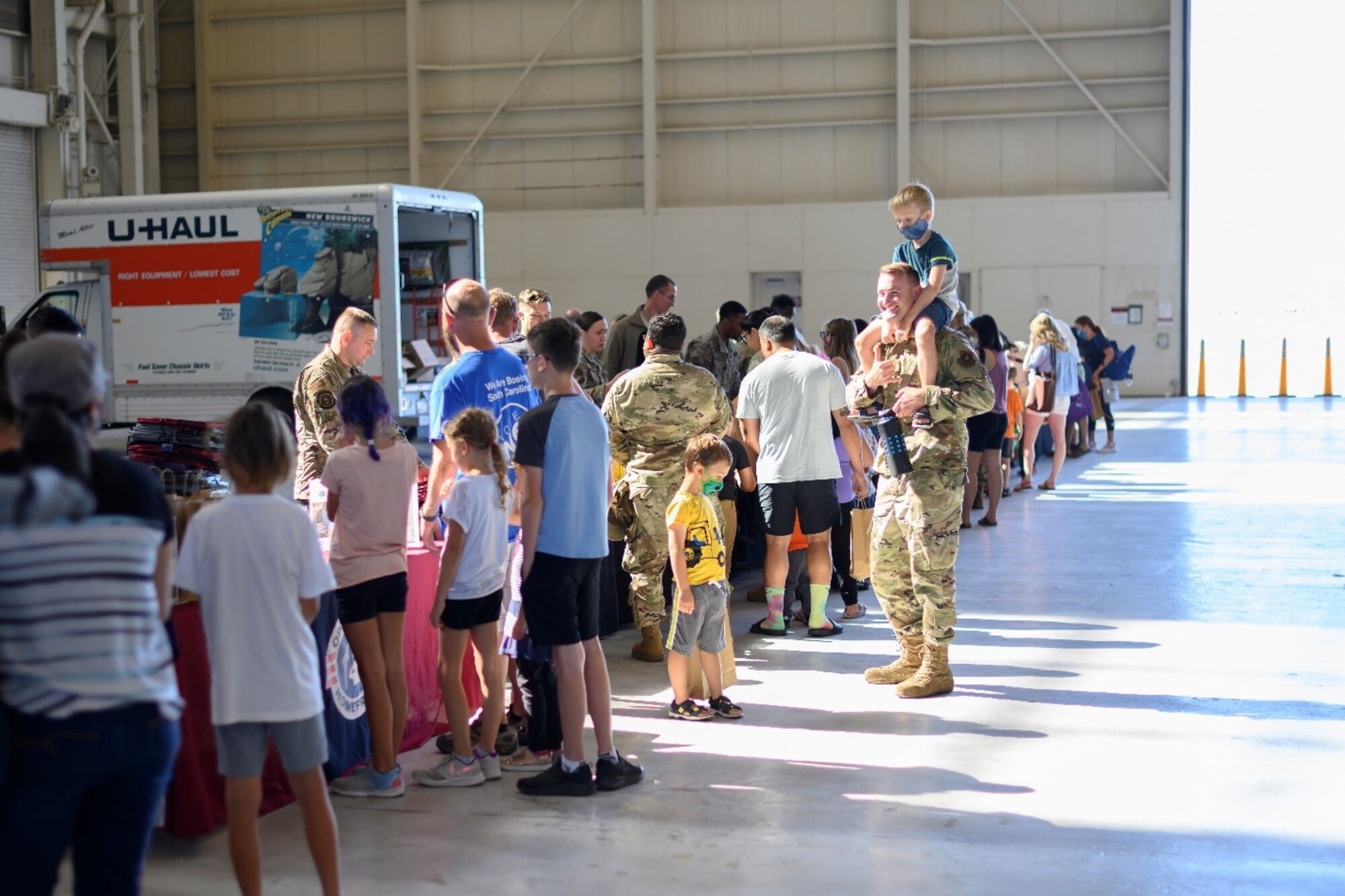 Airmen, parents and students line up along a string of tables to look over a selection of free school supplies at the Back-to-School Brigade July 23, 2021, at Travis Air Force Base, California. The Back-to-School Brigade is an annual tradition for the base ensuring all returning students have the resources they need ahead of the start of the new school year. (U.S. Air Force photo by Staff Sgt. Christian Conrad)