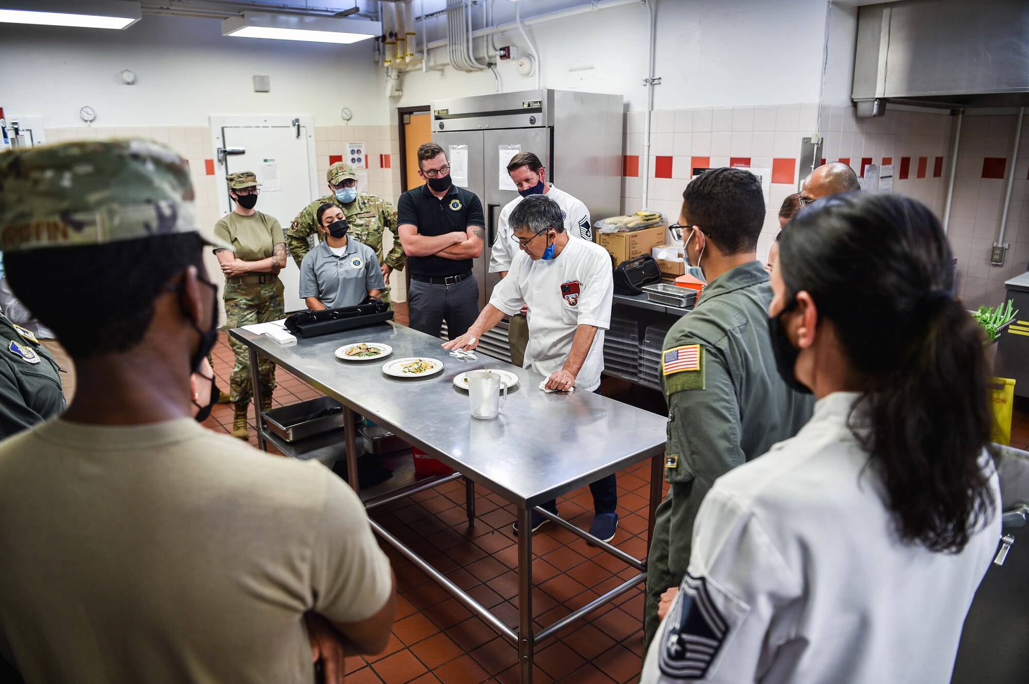 Celebrity chef, Roy Yamaguchi, provides feedback on three separate dishes created by Airmen and Sailors during an impromptu cooking competition at Hale Aina Dining Facility at Joint Base Pearl Harbor-Hickam, Hawaii, July 21, 2021. Yamaguchi provided feedback on how each dish tasted and where improvements can be made to each of the teams. (U.S. Air Force photo by Senior Airman Alan Ricker)