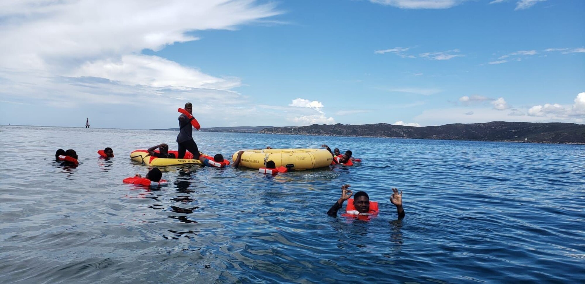Jamaican Defense Force Air Wing aircrewmen employ water survival and life raft deployment techniques June 24, 2021, in Kingston Harbour, Jamaica. Air advisors with the 571st Mobility Support Advisory Squadron spent weeks training JDF-AW forces on topics such as radio etiquette, maintenance, aircraft mishap and water survival. (Courtesy photo)