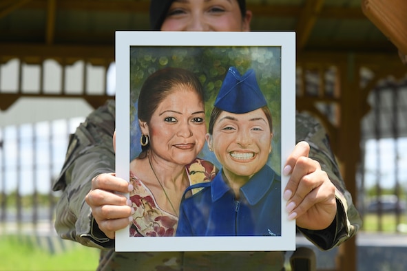 Airman 1st Class Jocelyn Soto holds a painting of her and her mother.