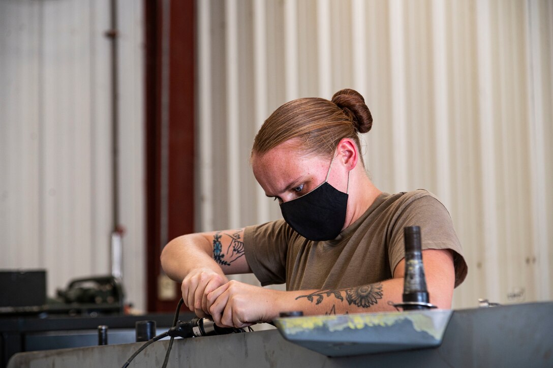 Photo of airman working on external fuel tank