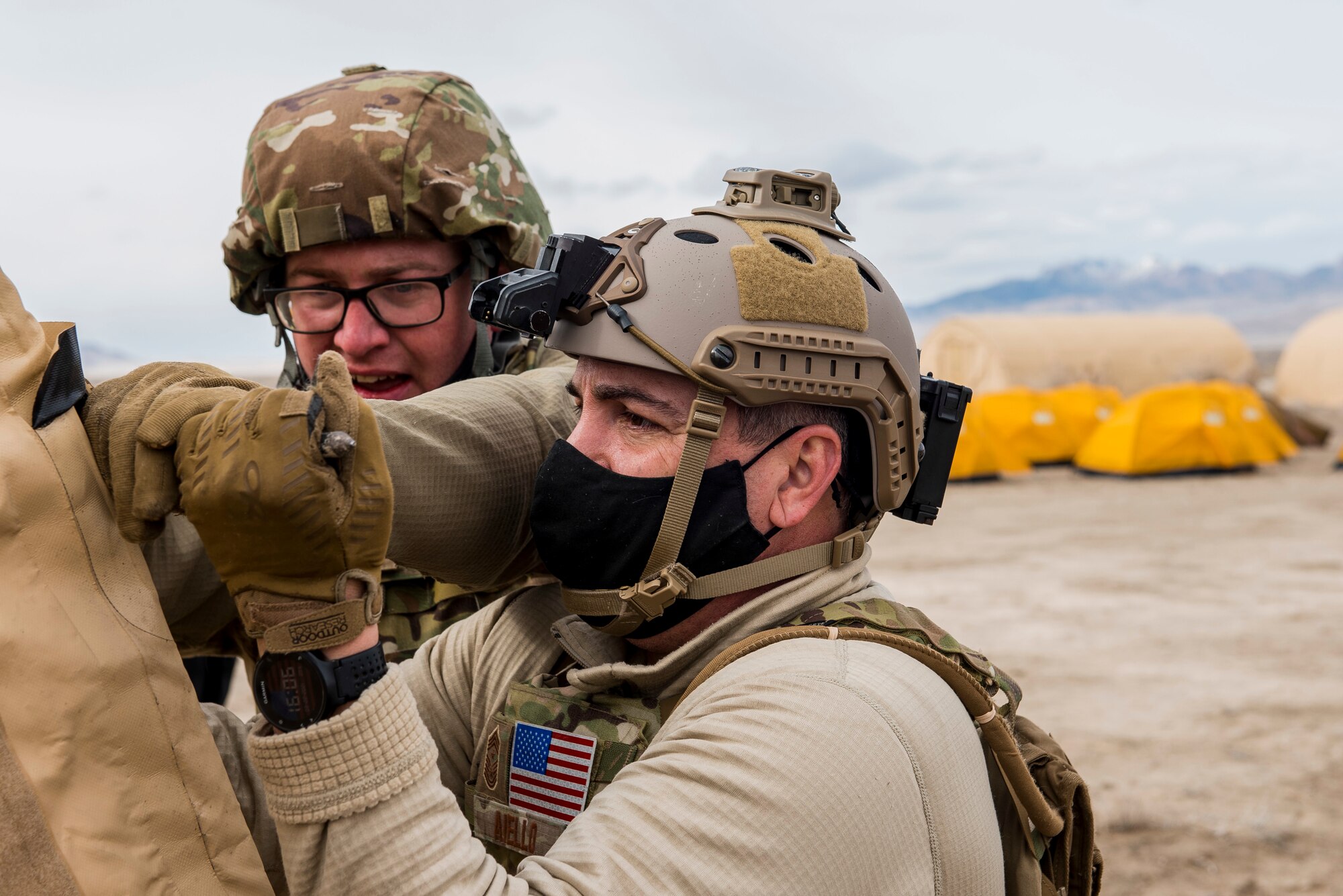 A 27th Special Operations Mission Support Team member assists 27th Special Operations Wing Command Chief Master Sergeant Sean Aiello during a 27 SOW operational readiness exercise at Dugway Proving Grounds, Utah, March 22, 2021. The Mission Support Team concept provides a way forward in building small, scattered teams capable of operating independent of main operating bases. (U.S. Air Force photo by Senior Airman Vernon R. Walter III)