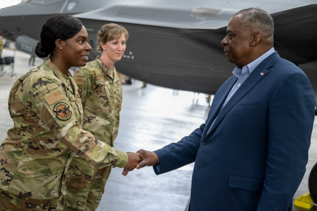 Secretary of Defense, Lloyd J. Austin III shakes hands with a service member.