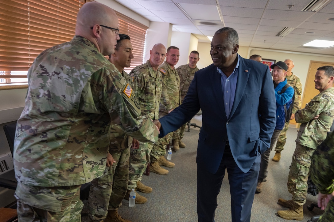 Secretary of Defense, Lloyd J. Austin III shakes hands with service members.