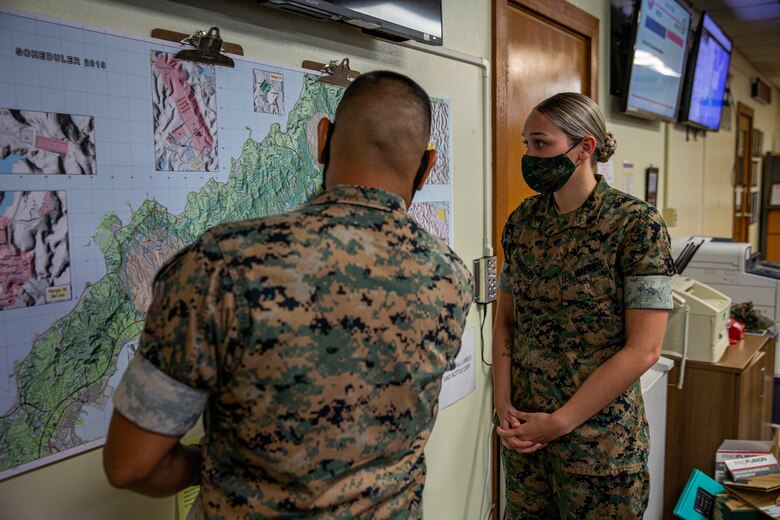 U.S. Marine Corps Cpl. Andreja Chambers, the current operations noncommissioned officer in charge with G-3, operations, training, plans, Marine Corps Installations Pacific, coordinates a training location with Gunnery Sgt. Anthony Zabala, the G-3 operations chief, on Camp Foster, Okinawa, Japan, July 23, 2021. Hailing from Rochester, New York, Chambers was recruited out of Recruiting Station Albany, and graduated recruit training from Marine Corps Recruit Depot Parris Island at the age of 17. A data systems administrator by trade upon her arrival to Okinawa in March of 2019, she has held numerous billets within G-6, communications, the COVID cell, and G-3, expanding her capabilities as a Marine and a noncommissioned officer. Zabala is a native of Selenas, California. (U.S. Marine Corps photo by Lance Cpl. Alex Fairchild)