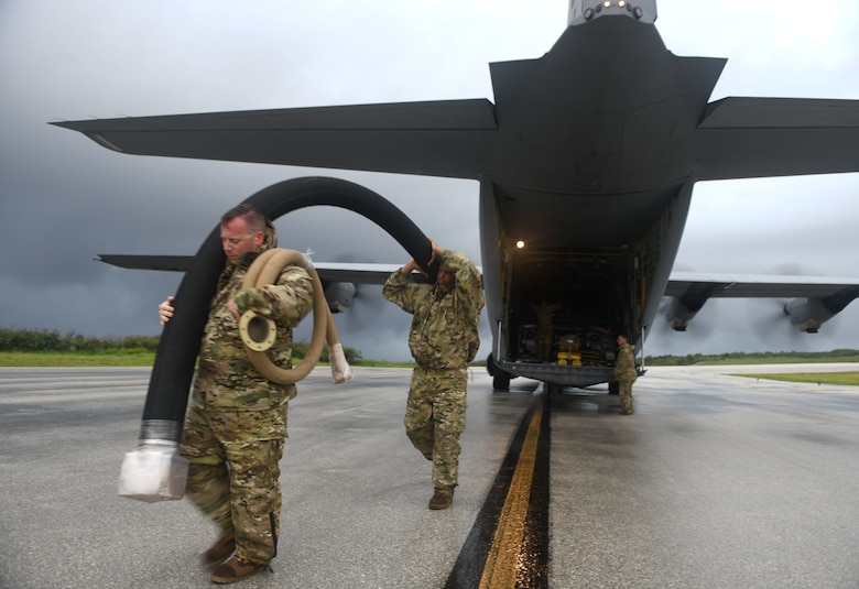 U.S. Air Force Tech. Sgt. Patrick Barlow, 366th Logistics Readiness Squadron acting fuels section chief, deployed from Mountain Home Air Force Base, Idaho, and Senior Airman William Pride, 354th LRS storage attendant, deployed from Eielson AFB, Alaska, unload a fuel hose from a C-130J Super Hercules July 21, 2021, at Tinian International Airport, Tinian, during Pacific Iron 2021. Pacific Iron 2021 is a Pacific Air Forces dynamic force employment operation to project forces into United States Indo-Pacific Command's area of responsibility in support of a more lethal, adaptive, and resilient force.