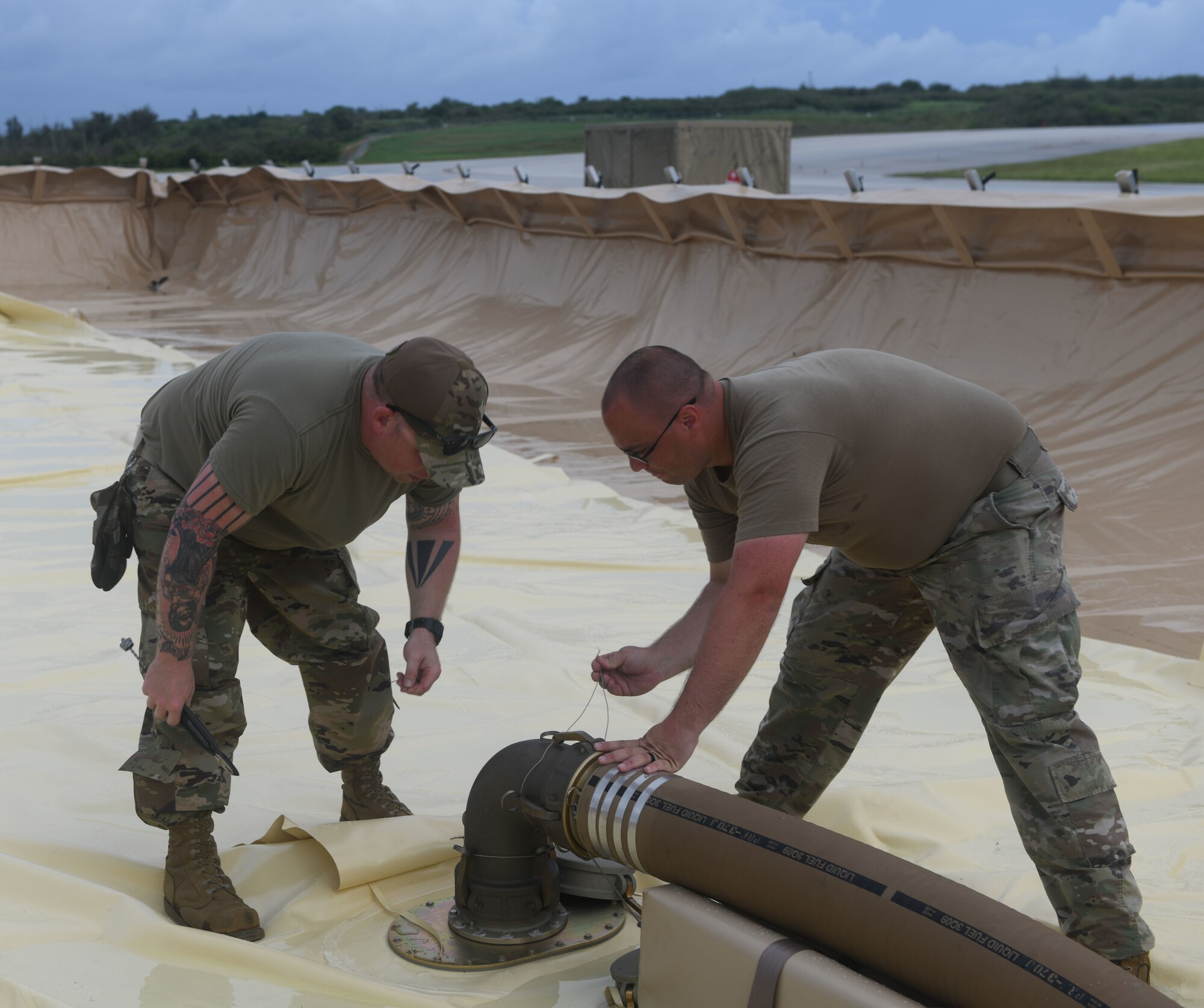 U.S. Air Force Tech. Sgt. Patrick Barlow, 366th Logistics Readiness Squadron acting fuels section chief, deployed from Mountain Home Air Force Base, Idaho, and Staff Sgt. Kyler Winters, 354th LRS fuels laboratory technician, deployed from Eielson AFB, Alaska, attach a fuel hose to a fuel bladder July 21, 2021, at Tinian International Airport, Tinian, during Pacific Iron 2021. Pacific Iron 2021 is a Pacific Air Forces dynamic force employment operation to project forces into United States Indo-Pacific Command’s area of responsibility in support of a more lethal, adaptive, and resilient force.