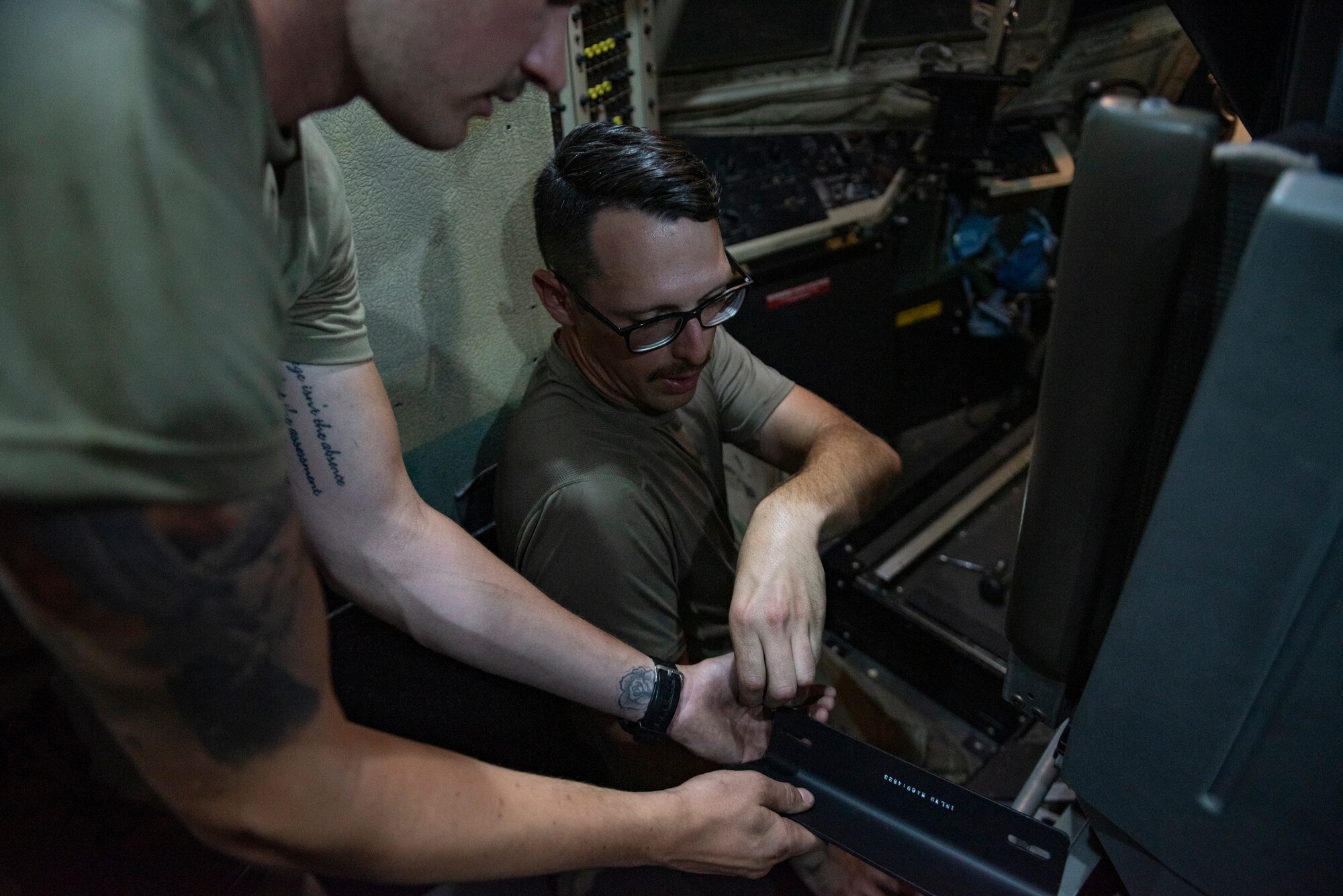 U.S. Air Force Tech. Sgt. Tyler Dowland, a crew chief assigned to the 386th Expeditionary Aircraft Maintenance Squadron and deployed from Maxwell Air Force Base, Alabama, hands bolts from a C-130 Hercules panel to U.S. Air Force Senior Airman Christian Pettus, a crew chief assigned to the 386th EAMXS and deployed from Maxwell AFB, at Ali Al Salem Air Base, Kuwait, July 20, 2021. The EAMXS works 24-hour operations year-round to keep the C-130 Hercules in flight to accomplish the mission of fight to win today and to provide warfighter support in the area of responsibility. (U.S. Air Force Photo by Senior Airman Helena Owens)