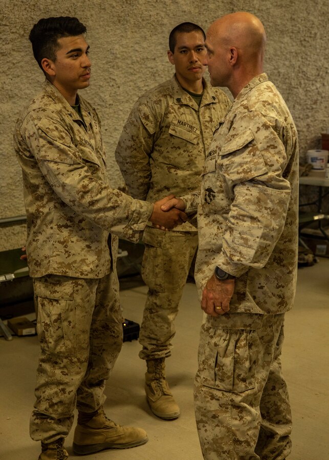 Lt. Gen. David G Bellon (Right), Commander, Marine Forces Reserve and Marine Forces South, presents a challenge coin to a Marine during Integrated Training Exercise (4-21) at Marine Corps Air Ground Combat Center Twentynine Palms, California on July 22, 2021. Lt. Gen. Bellon visited all elements of Marine Air Ground Task Force (MAGTF) 25 and recognized high performing Marines and Sailors as they continue to provide vital support to the MAGTF in execution of ITX. (U.S. Marine Corps photo by Lance Cpl. Samwel tabancay)
