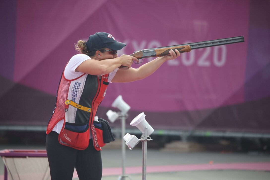 An athlete fires her weapon during a competition.