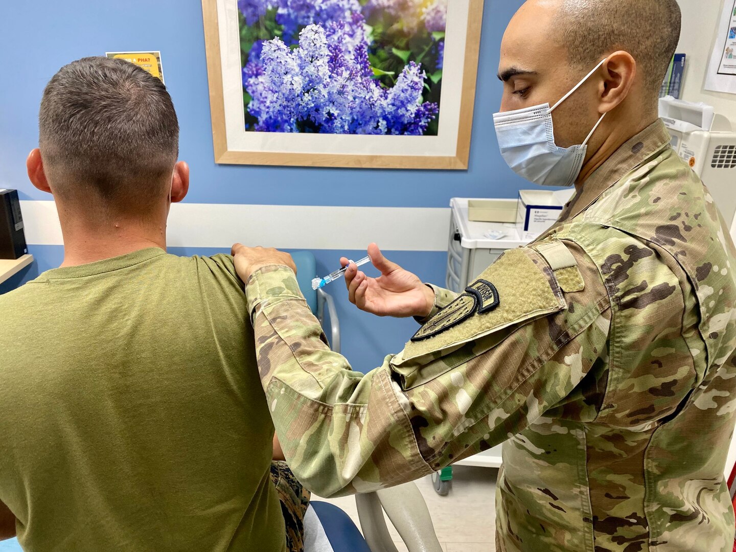 Sgt. Jonathan Harris, 3rd Battalion, 353rd Infantry Regiment, vaccinates Lance Cpl. Mason Brennan, 1st Battalion, 23rd Marine Regiment at the Soldier Center Medical Home clinic during his annual periodic health assessment at the Joint Readiness Training Center and Fort Polk, La. on July 22.