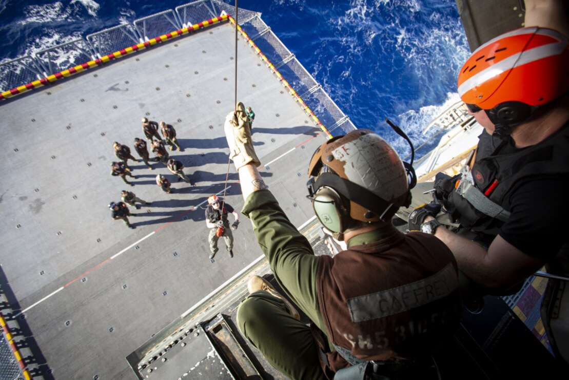 U.S. Marine Corps crew chiefs with Marine Medium Tiltrotor Squadron 265, 31st Marine Expeditionary Unit, and Navy crew chiefs with Helicopter Sea Combat Squadron 25, lowers a Sailor from an MV-22B Osprey during integrative advanced hoist training aboard the amphibious assault ship USS America in the Coral Sea, July 16, 2021. Navy crew chiefs with HSC-25 instructed Marine crew chiefs with VMM-265 on how to lower advanced rescue equipment for lifting service members out of the water during emergency situations. The 31st MEU is operating aboard ships of the America Expeditionary Strike Group in the U.S. 7th fleet area of operations to enhance interoperability with allies and partners and serve as a ready response force to defend peace and stability in the Indo-Pacific region.