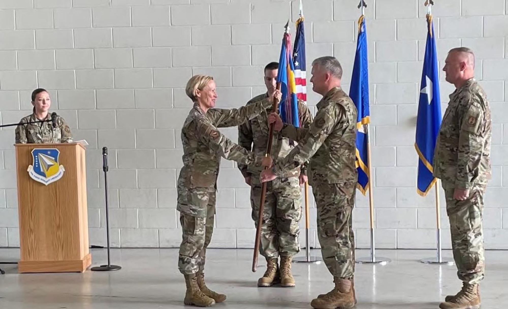 Maj Gen Heather Pringle, AFRL commander, passes the Munitions Directorate flag to Col. Woodrow "Tony" Meeks at the Munitions Directorate change of command ceremony at Eglin AFB July 13. (U.S. Air Force photo/John Leake)