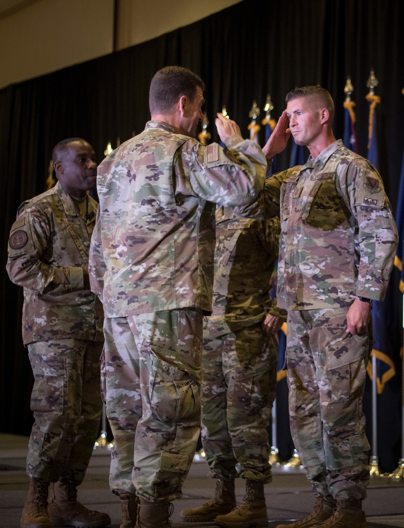 U.S. Air Force Senior Master Sgt. Mark Schneider II, right, of the 179th Airlift Wing, Ohio National Guard, salutes Lt. Gen. Michael A. Loh, director, Air National Guard, upon receiving a coin at the Air National Guard Senior Leader Conference in St. Louis, Missouri, July 20, 2021. Schneider, the ANG’s outstanding senior noncommissioned officer of the year, was recognized for superior leadership, job performance and achievements.