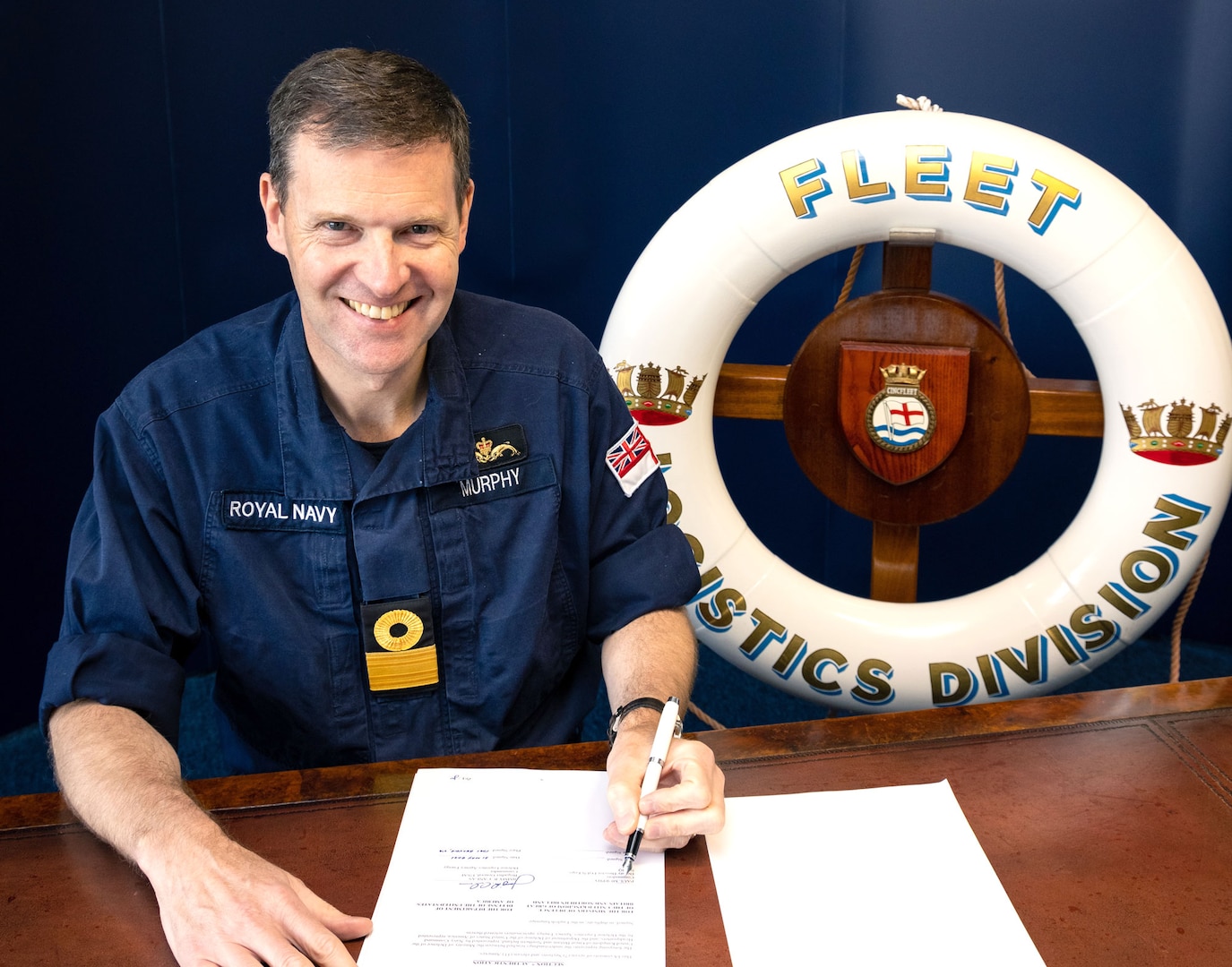 United Kingdom Navy Commadore Paul Murphy signing a document