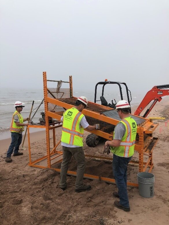 U.S Army Corps of Engineers, Duluth Area Office Floating Plant crew designed and fabricated a screening machine to filter the debris from the beach on Minnesota Point.  The crew placed a larger 1” Screen on top and the bottom screen contained ¼” openings.  The crew placed the dredged material on the screen and utilized a vibrating mechanism and water to sort the rocks, wood debris and human made debris from the beach.  The crew has completed all required cleanup areas on the beach from the FY20 Dredging contract