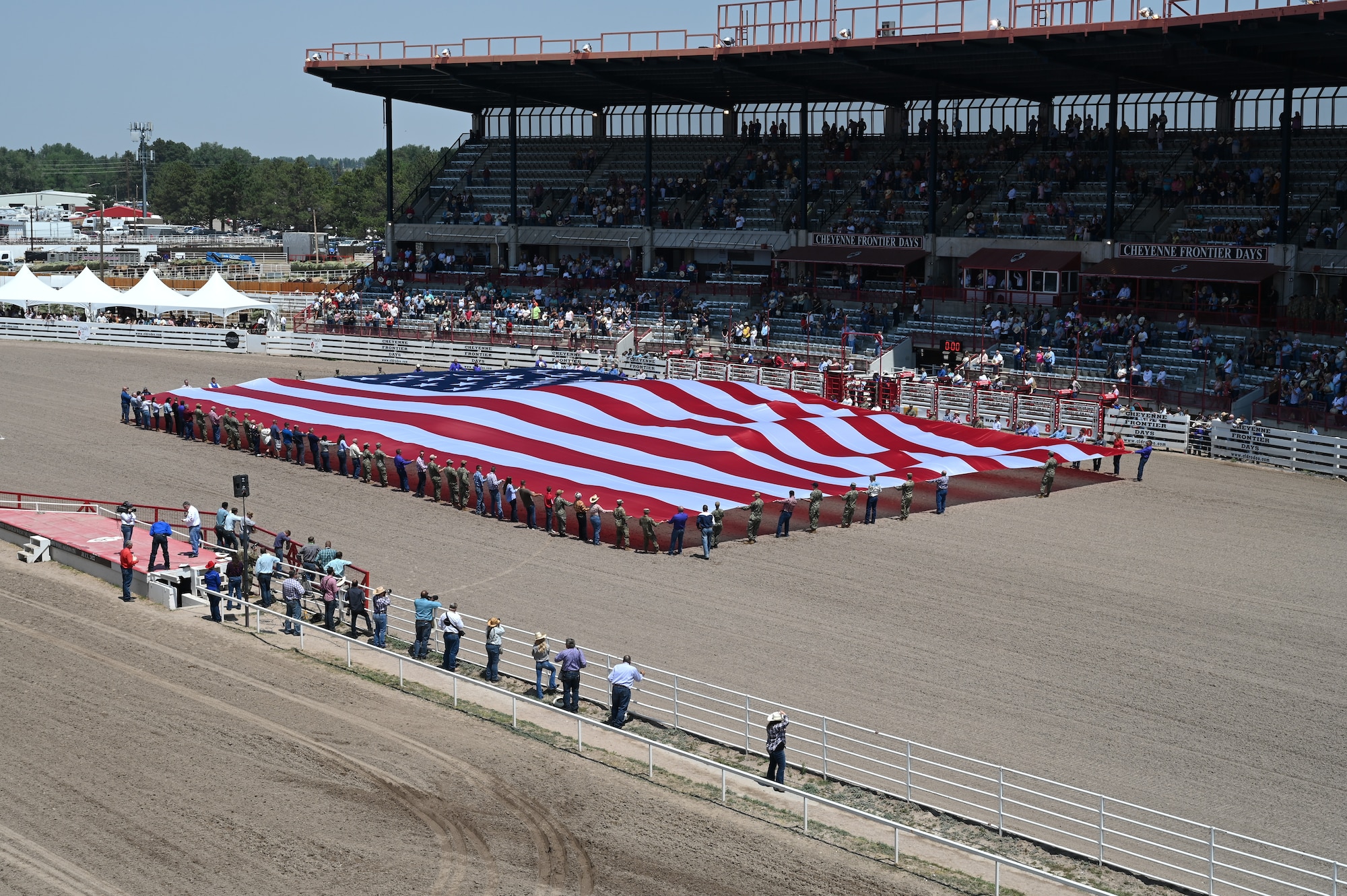 Members of the military and local community present the American flag during Military Monday at Frontier Park in Cheyenne, Wyo., July 26, 2021. The flag presentation is an annual tradition at Cheyenne Frontier Days and Military Monday honors those serving in the local community and provides an opportunity to showcase the strong relationship between the base and the local community.  (U.S. Air Force photo by Glenn S. Robertson)