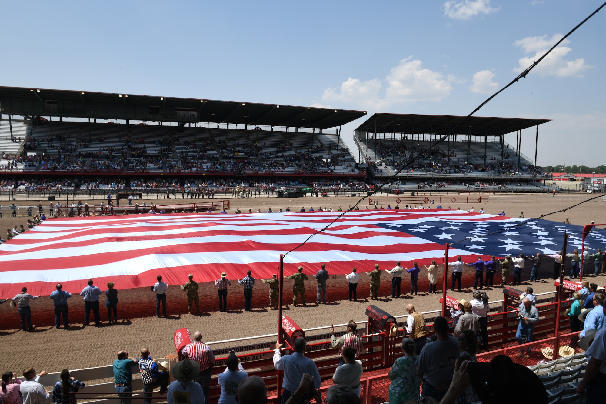Members of the military and local community present the American flag during Military Monday at Frontier Park in Cheyenne, Wyo., July 26, 2021. The flag presentation is an annual tradition at Cheyenne Frontier Days and Military Monday honors those serving in the local community and provides an opportunity to showcase the strong relationship between the base and the local community. (U.S. Air Force photo by Staff Sgt. Tyler Placie)