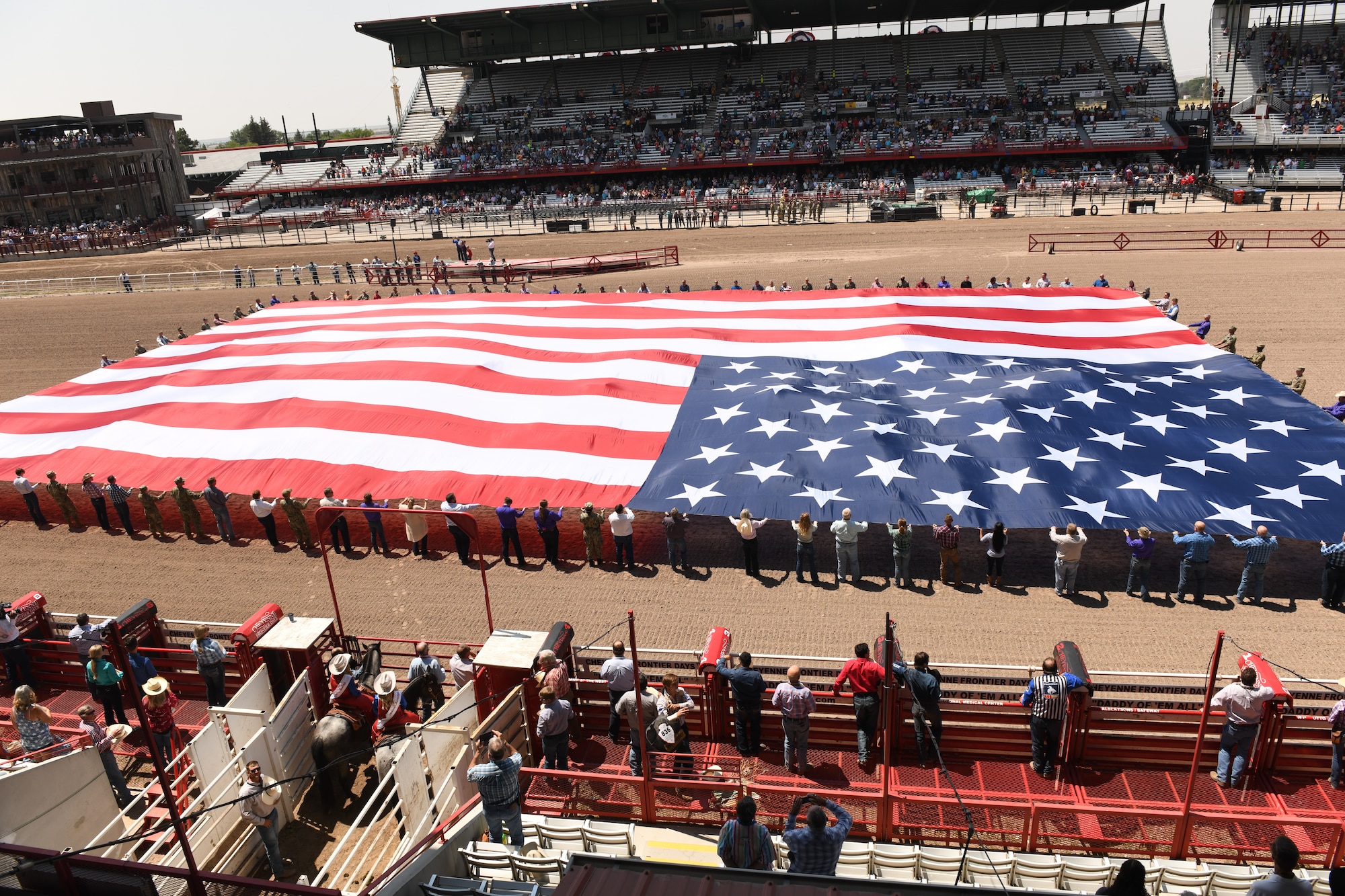 Members of the military and local community present the American flag during Military Monday at Frontier Park in Cheyenne, Wyo., July 26, 2021. The flag presentation is an annual tradition at Cheyenne Frontier Days and Military Monday honors those serving in the local community and provides an opportunity to showcase the strong relationship between the base and the local community.  (U.S. Air Force photo by Airman 1st Class Darius R. Frazier)