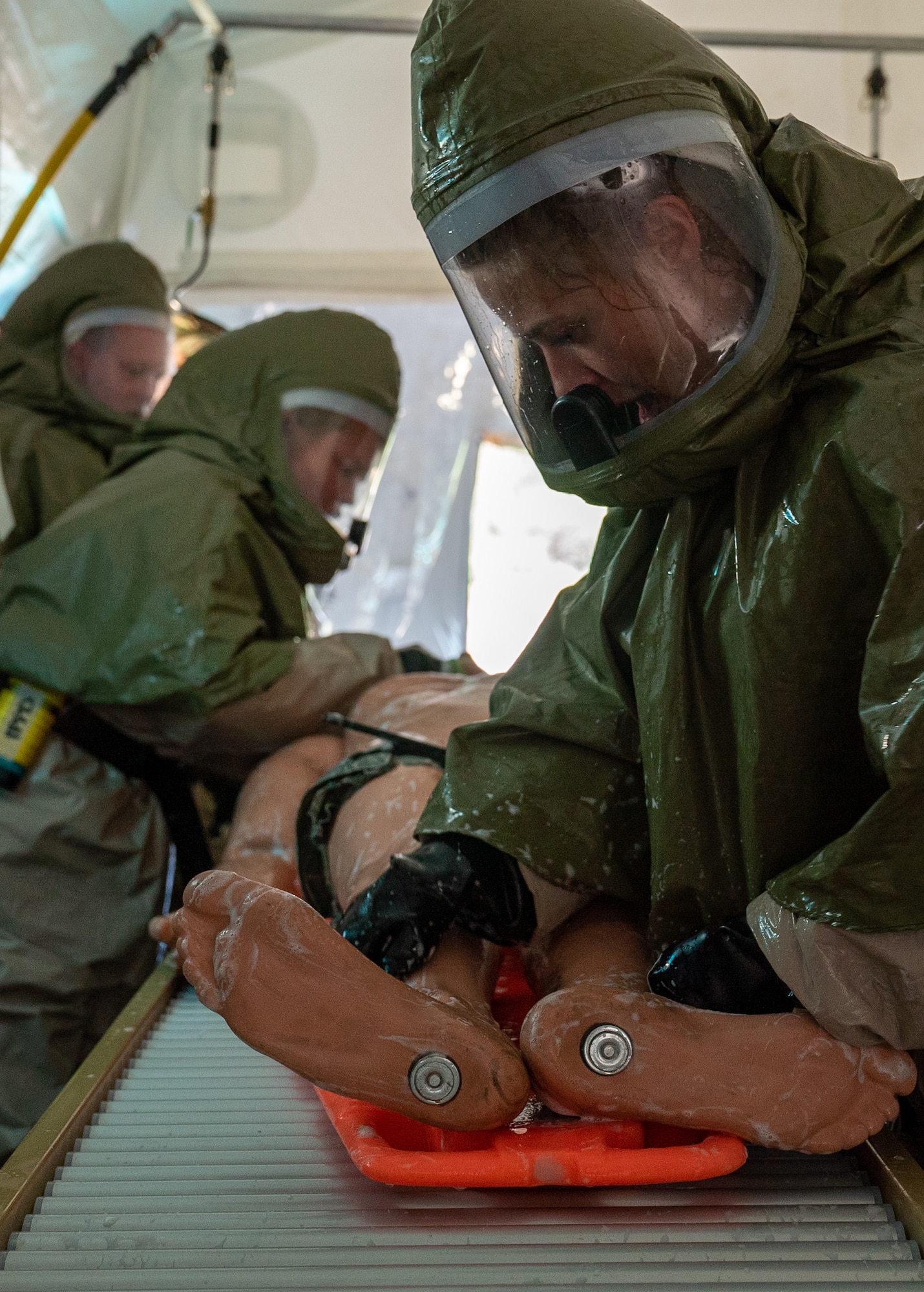 Airmen scrub down a mannequin during a decontamination training exercise.