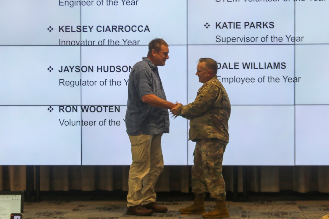 Outreach Specialist Ron Wooten receives a commander's coin from Galveston District Commander Col. Tim Vail during an awards ceremony held July 1, 2021, at the District's headquarters. Wooten earned the coin for being named the Galveston District’s “Volunteer of the Year." Wooten leads all senior leadership and stakeholder visits, where he goes above and beyond to coordinate all logistics aspects of high-profile visits. His photography skills also proved invaluable to the district’s public affairs mission, where he volunteers to provide photo support whenever necessary.