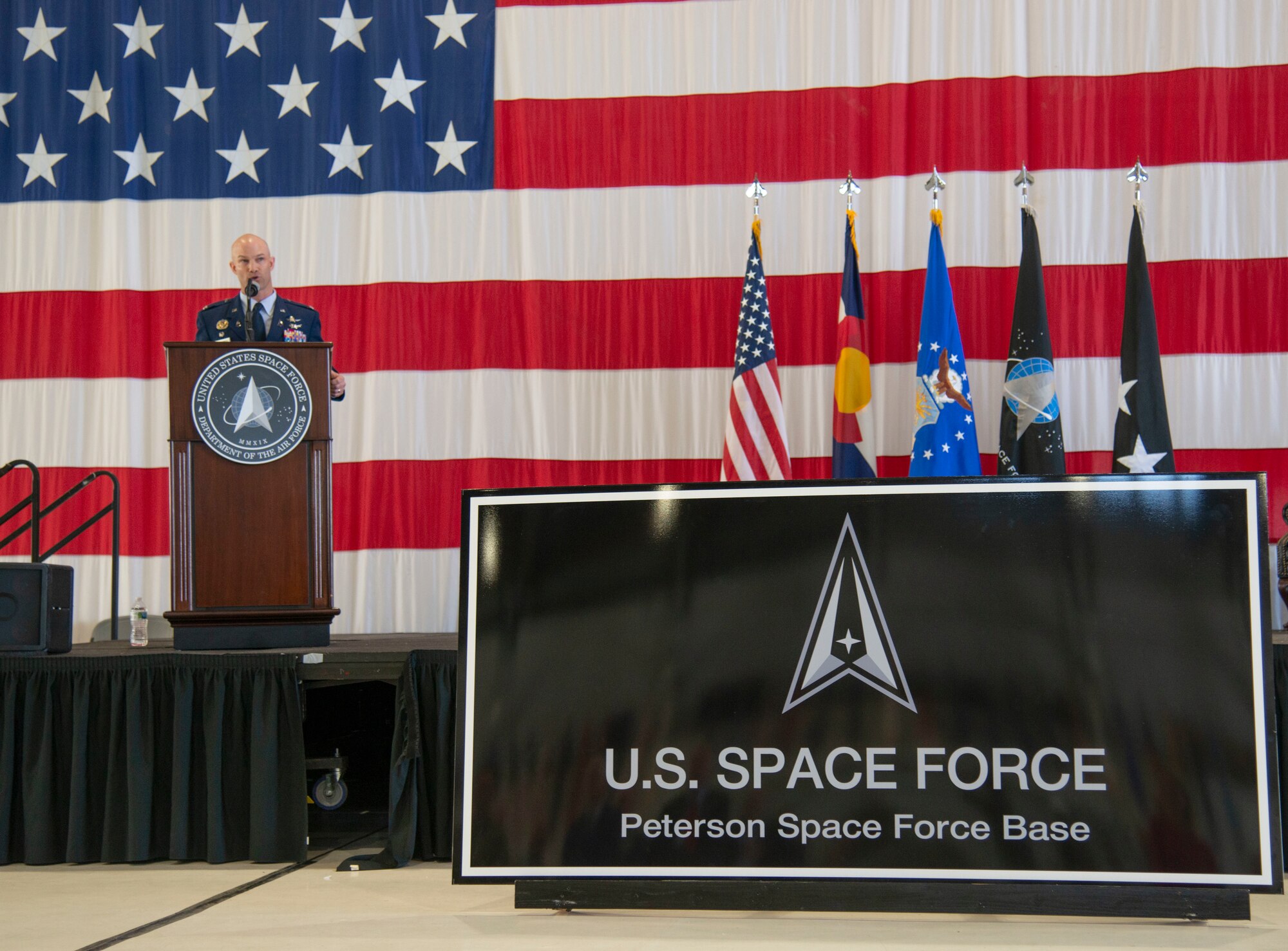 Peterson-Schriever Garrison commander speaks at a podium during the base renaming ceremony