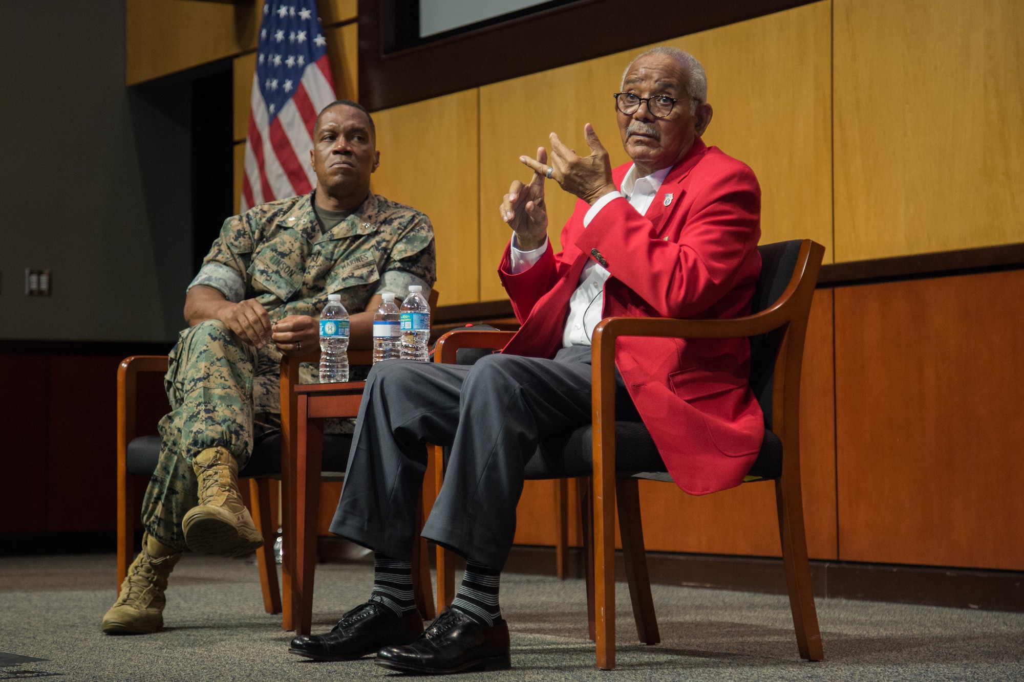 Documented Original Tuskegee Airman, U.S. Army Air Forces Sgt. Thomas Newton, right, relates his experiences serving in the 99th Fighter Squadron from 1946-1949, while host U.S. Marines Lt. Col. Karl Tinson, left, listens along with a packed audience of U.S. Central Command personnel in the Vince Tolbert Building, MacDill Air Force Base, July 9, 2021. Tuskegee Airmen were a famous group of African American pilots, bombers, and their support personnel who fought in World War II. (U.S. Army photo by Spc. Robert Vicens)