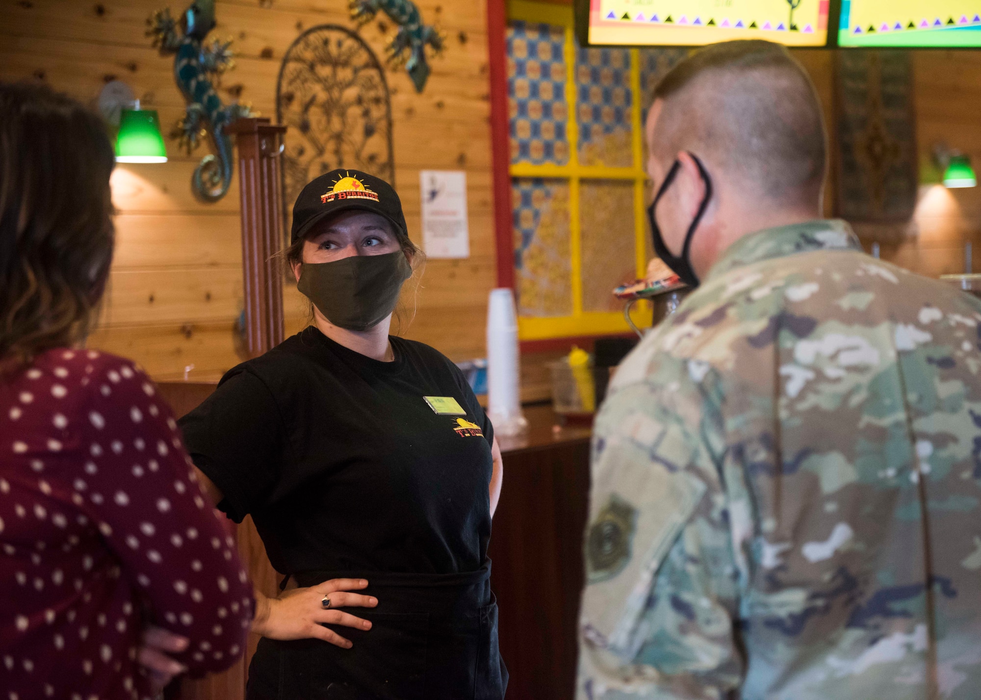 Civilians and a service member talk to each other.