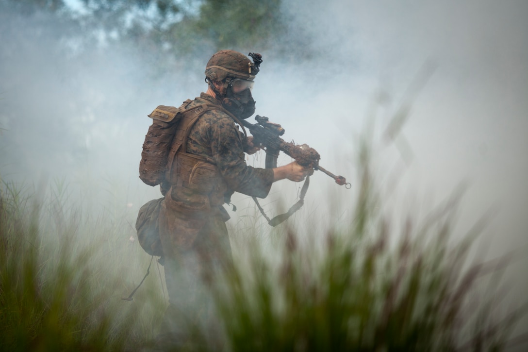 U.S. Marine Cpl. James K. Gordan II, a rifleman with 1st Battalion, 7th Marine Regiment, reacts to a surprise gas attack during the Advanced Infantry Course aboard Kahuku Training Area, Hawaii, July 20, 2016. AIC is intermediate training designed to enhance and test the Marine's skills and leadership abilities as squad leaders in a rifle platoon.