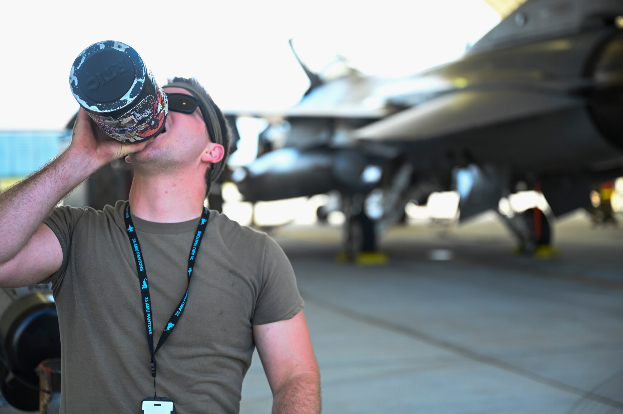 An Airman drinks from a water bottle.