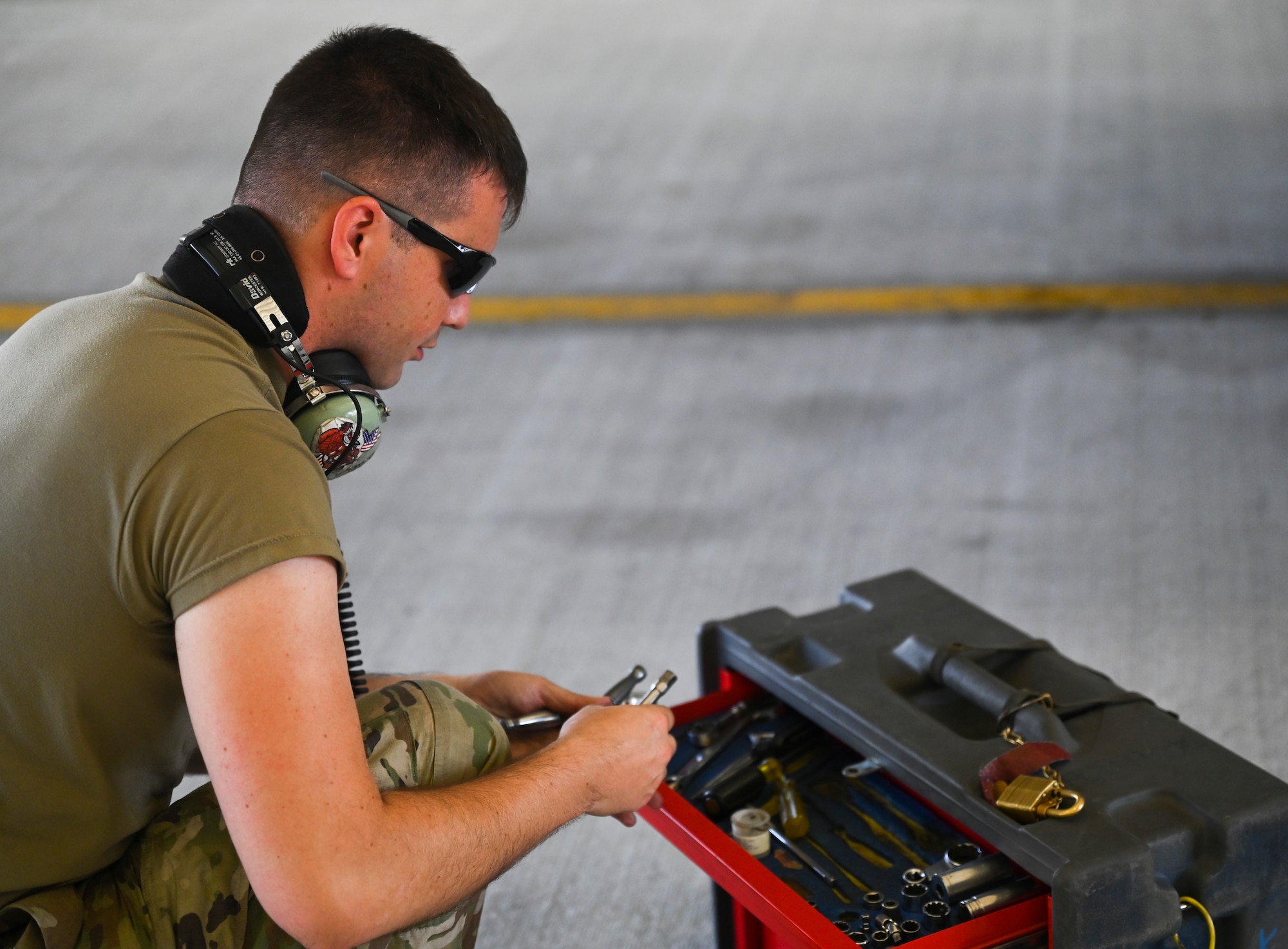 An Airman sorts through his toolbox in a hangar.