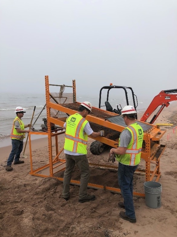 U.S Army Corps of Engineers, Duluth Area Office Floating Plant crew designed and fabricated a screening machine to filter the debris from the beach on Minnesota Point.  The crew placed a larger 1” Screen on top and the bottom screen contained ¼” openings.  The crew placed the dredged material on the screen and utilized a vibrating mechanism and water to sort the rocks, wood debris and human made debris from the beach.  The crew has completed all required cleanup areas on the beach from the FY20 Dredging contract