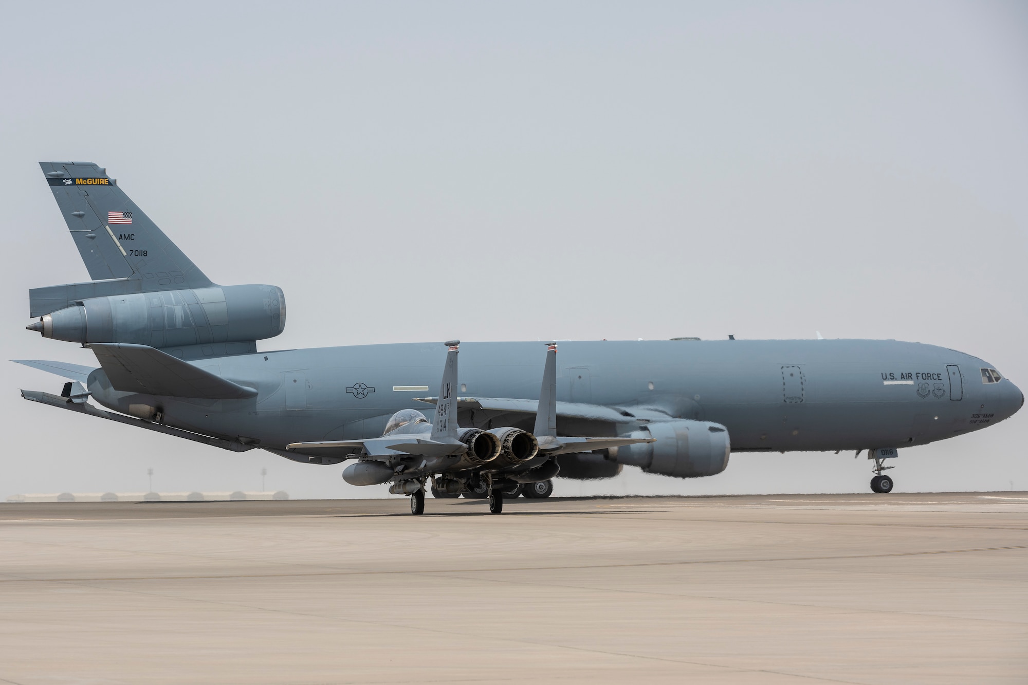 A Kc-10 and an F-15E taxi onto the runway