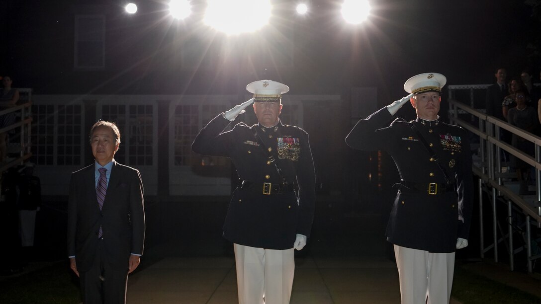 From left, Koji Tomita, Ambassador Extraordinary and Plenipotentiary of Japan to the United States, Lt. Gen. Mark R. Wise, Deputy Commander for Aviation, and Col. Teague A. Pastel, the commanding officer of Marine Barracks Washington, stand at the position of attention and render a salute during the Friday Evening Parade at MBW, July 23, 2021.