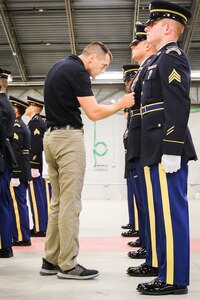 Kevin Palladino, one of just two national trainers for the Army National Guard Military Funeral Honors Program, meticulously inspects a Soldier’s Army Service Uniform during the intense two-week Level 2 Funeral Honors Course held July 11-24 at Fort Indiantown Gap, Pa.