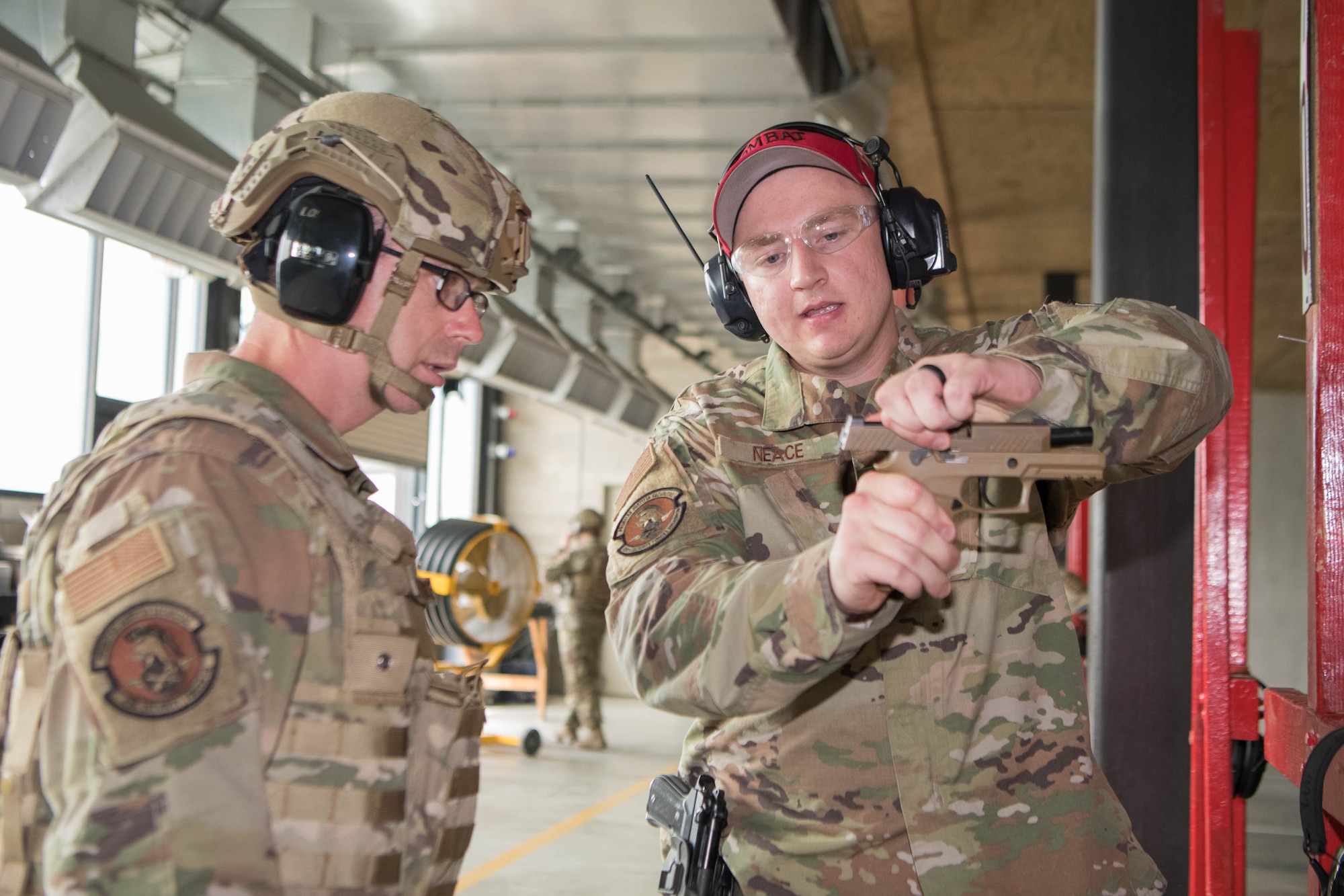 Senior Airman Nicholas Neace, right, 436th Security Forces Squadron Combat Arms Training and Maintenance instructor, gives Chief Master Sgt. Timothy Bayes, 436th Airlift Wing command chief, a weapon safety brief at the CATM facility on Dover Air Force Base, Delaware, July 26, 2021. Bayes toured the facility and fired the M18 pistol and M4 carbine. (U.S. Air Force photo by Mauricio Campino)