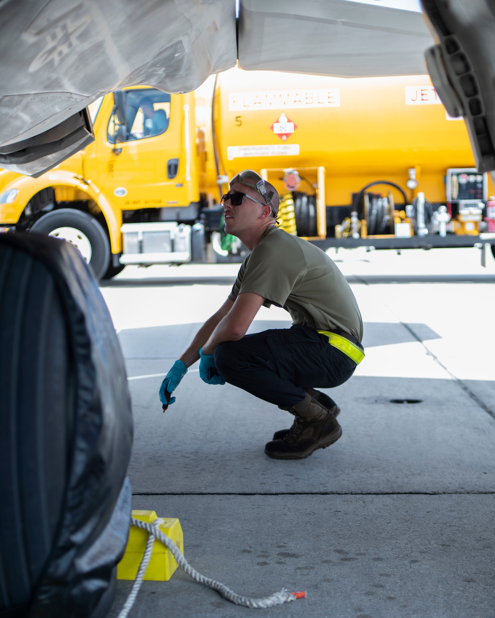 Man squats beneath a place to inspect it