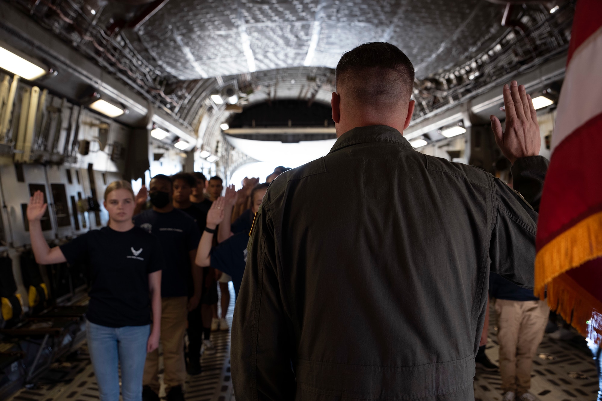 U.S. Air Force Col. David Fazenbaker, 62nd Airlift Wing commander, administers the oath of enlistment to future Airmen in the 361st Recruiting Squadron Delayed Entry Program on board a C-17 Globemaster III at Joint Base Lewis-McChord, Washington, July 23, 2021. The future Airmen, along with their recruiters visited several facilities at JBLM before touring a C-17 static display and taking their oath of enlistment. (U.S. Air Force photo by Senior Airman Zoe Thacker)
