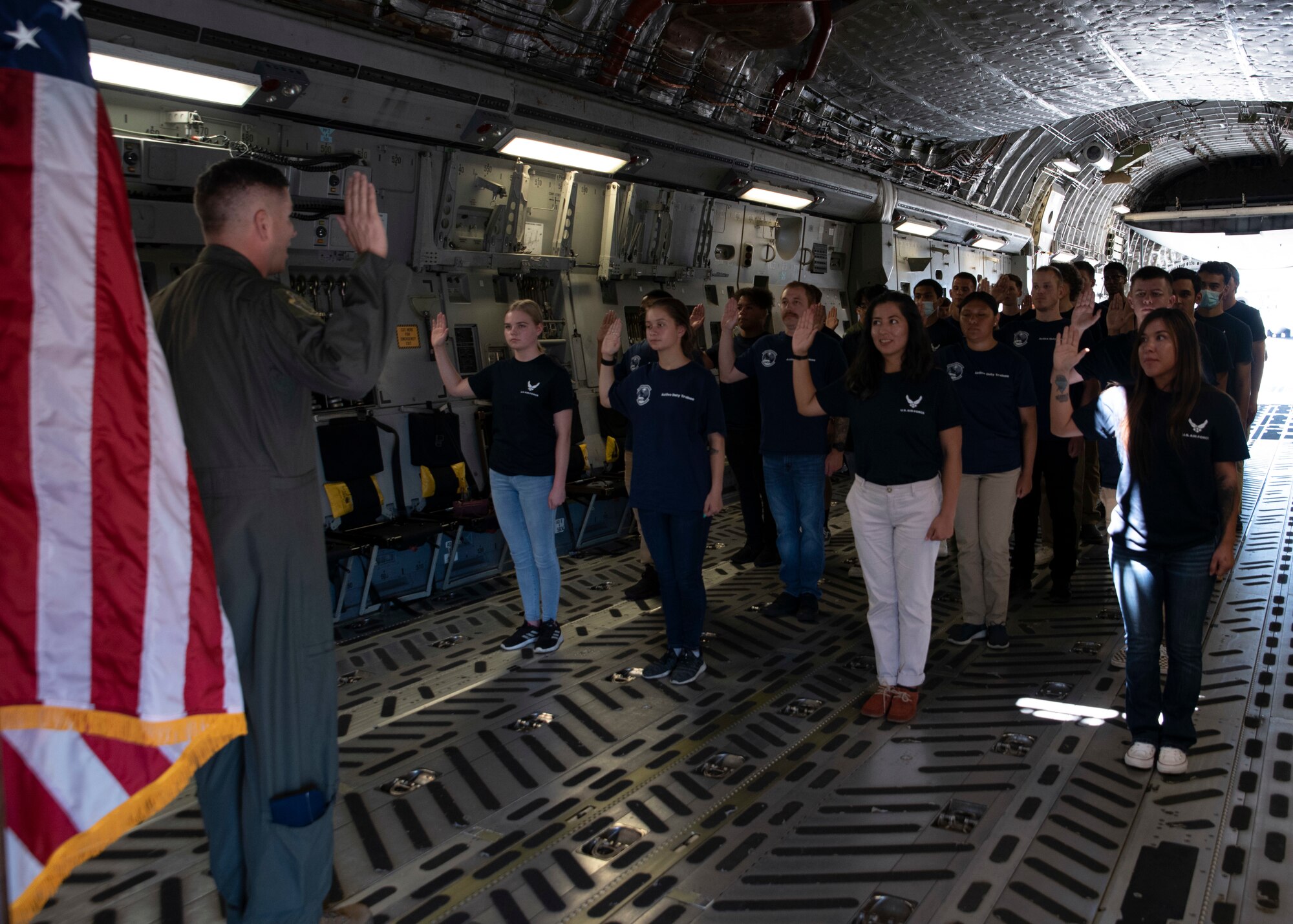 U.S. Air Force Col. David Fazenbaker, 62nd Airlift Wing commander, administers the oath of enlistment to future Airmen in the 361st Recruiting Squadron Delayed Entry Program on board a C-17 Globemaster III at Joint Base Lewis-McChord, Washington, July 23, 2021. The future Airmen, along with their recruiters with the 361st Recruiting Squadron, visited several facilities at JBLM before touring a C-17 static display and taking their oath of enlistment. (U.S. Air Force photo by Senior Airman Zoe Thacker)