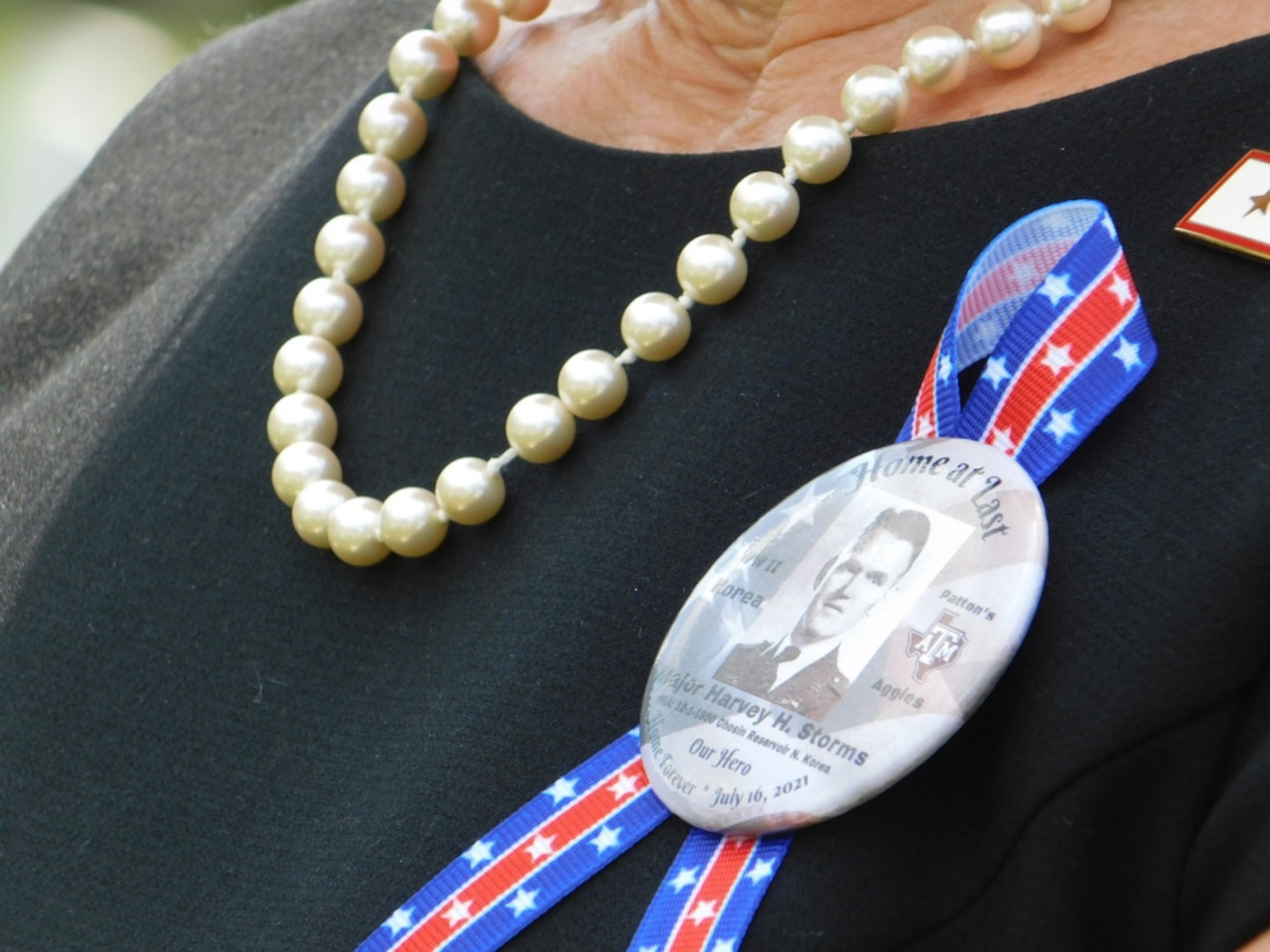 An attendee at the funeral for Army Major Harvey Storms wears a ribbon to remember the Texas native who was buried in Arlington National Cemetery on July 16, 2021. Major Storms was reported missing in action on Dec. 1, 1950, when his unit was attacked by enemy forces near the Chosin Reservoir, North Korea. Following the battle, his remains could not be recovered. The Defense POW/MIA Accounting Agency was able to identify the remains in 2019. (Defense Photo by Ashley M. Wright)