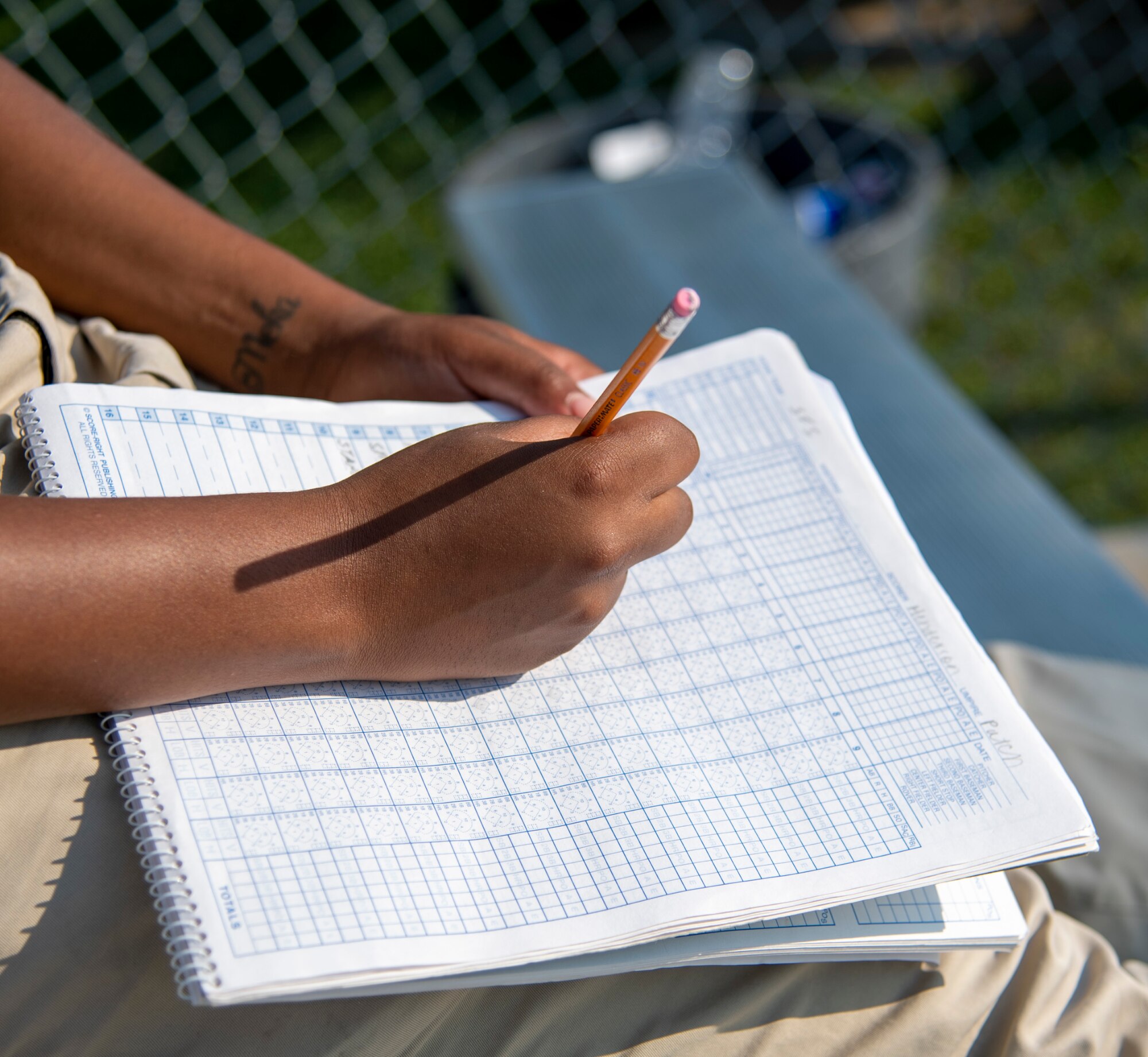 Airman 1st Class Cherish Henderson, 436th Force Support Squadron fitness center specialist, maintains the official scorebook during an intramural softball game between the 436th Security Forces Squadron and the 436th Maintenance Squadron Isochronal Maintenance Dock on Dover Air Force Base, Delaware, July 26, 2021. The 436th SFS won the game 13-4. (U.S. Air Force photo by Tech. Sgt. Nicole Leidholm)