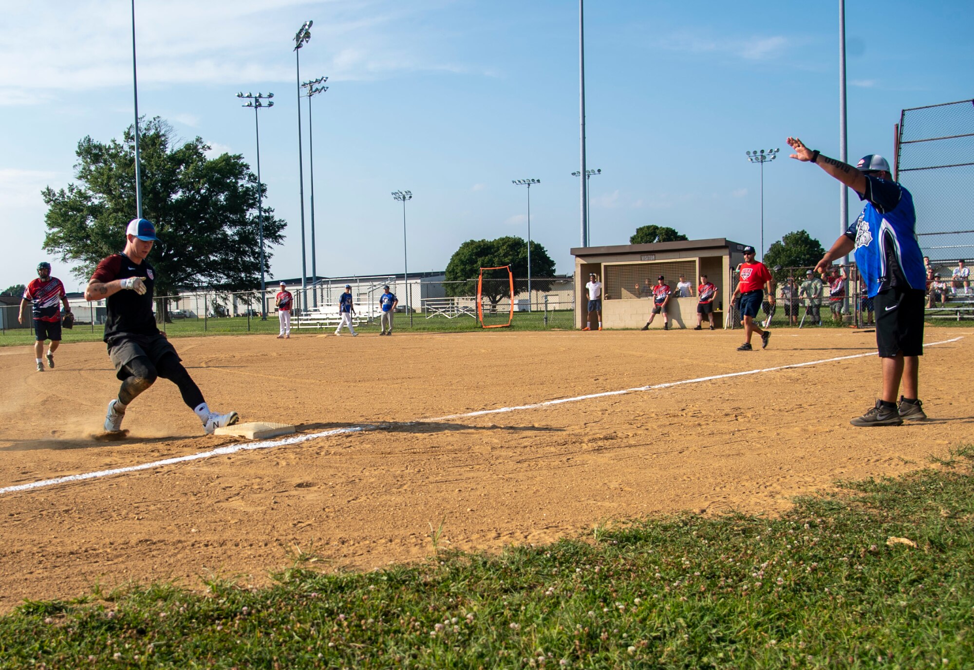 Senior Airman Noah Smith, left, 436th Security Forces Squadron response force member, reaches third base as Rafael Gonzalez, 436th SFS detective, coaches during an intramural softball game on Dover Air Force Base, Delaware, July 26, 2021. The 436th SFS won the game 13-4. (U.S. Air Force photo by Tech. Sgt. Nicole Leidholm)