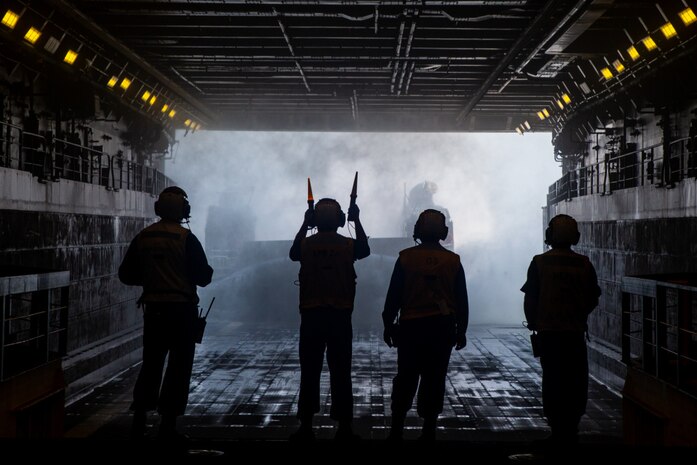 A U.S. Navy landing craft, air cushion is marshaled into the USS Arlington carrying tactical vehicles during Defense Support of Civil Authorities mission rehearsals at Naval Base Norfolk, Virginia, July 21, 2021. Marines and Sailors with the II Marine Expeditionary Force Maritime DSCA Task Force, commanded by Combat Logistics Battalion 22, and Sailors aboard the USS Arlington conducted a destructive weather mission rehearsal loading exercise to prepare and rehearse for a future DSCA mission during the 2021 hurricane season.
