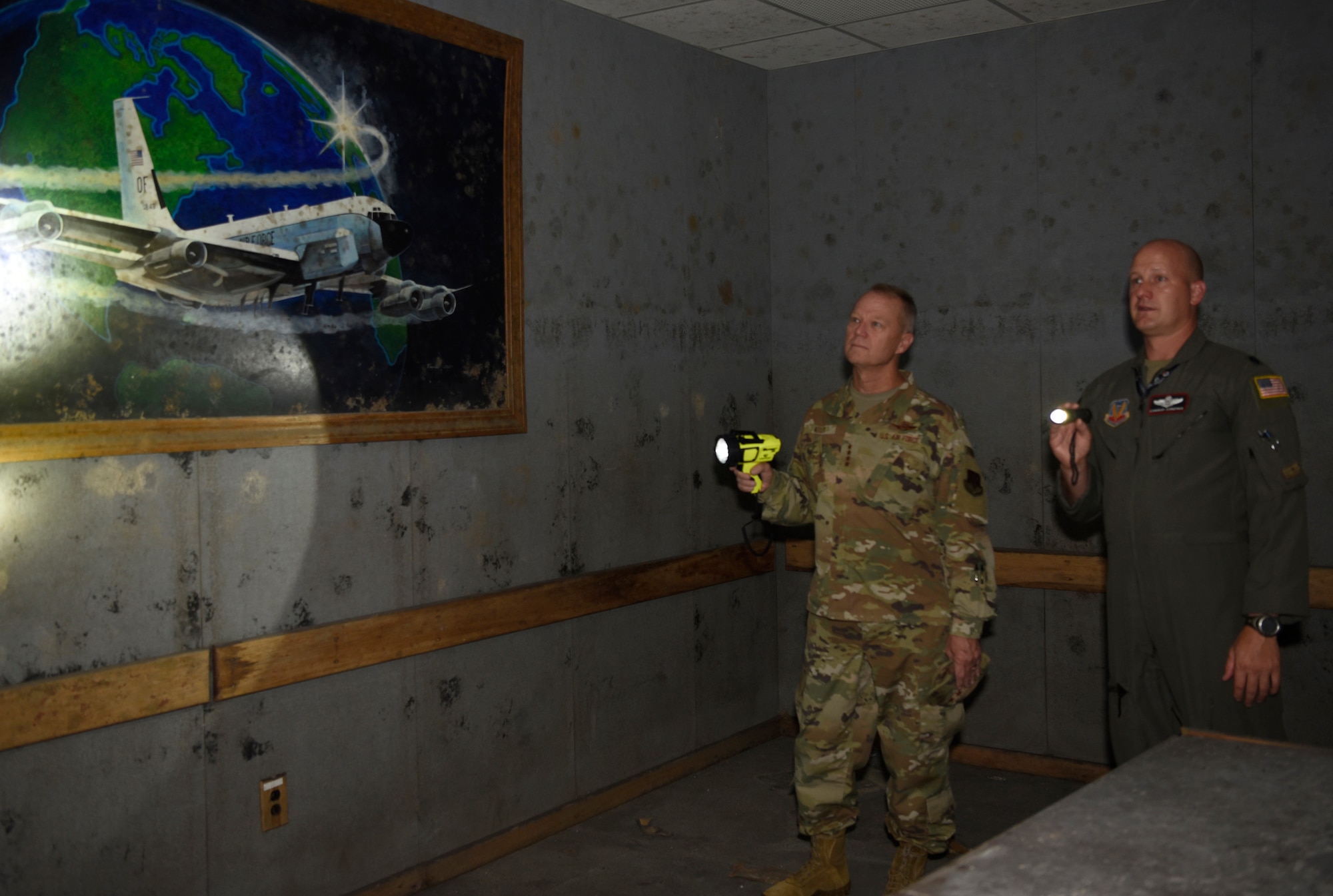 Two uniformed Air Force Airmen stand and go over a brief.