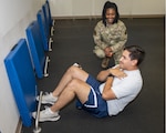 Photo By Airman 1st Class Kimberly Barrera | Senior Airman Kevin McMahon, 333rd Fighter Squadron weapons load crew member, performs sit-ups while Senior Airman Deja Moultrie, 916th Force Support Squadron service technician counts his repetitions at Seymour Johnson Air Force Base, North Carolina, July 15, 2021. Fitness assessments help ensure combat readiness and align with the needs of the mission of the Department of Defense and the U.S. Air Force (U.S. Air Force photo by Senior Airman Kimberly Barrera)