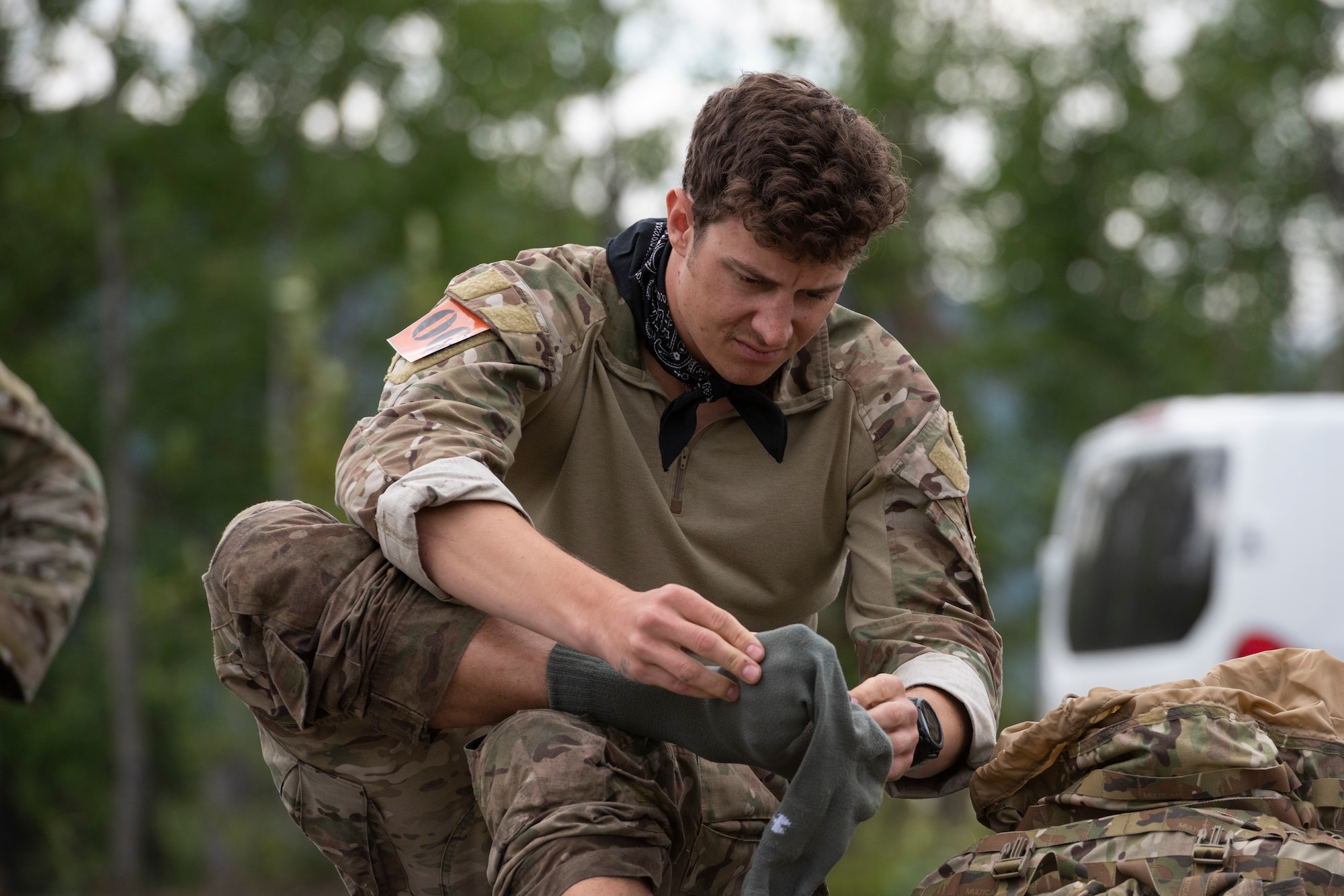 U.S. Air Force Staff Sgt. Garrett Geske, tactical air control party (TACP) specialist, 3rd Air Support Operations Squadron, changes his socks after completing a land navigation event during the Chaos Challenge 2021 at Joint Base Elmendorf-Richardson, Alaska, July 14, 2021. The Chaos Challenge 2021 was a multi-day series of mental and physical contests sponsored by the 1st Air Support Operations Group with participants from the 3rd, 5th, 25th, and 604th Air Support Operations Squadrons and a guest team from the 673d Security Forces Squadron. The winner of the competition will go on to compete in Lightning Challenge 2021 to determine the best two-man TACP team in the Air Force.