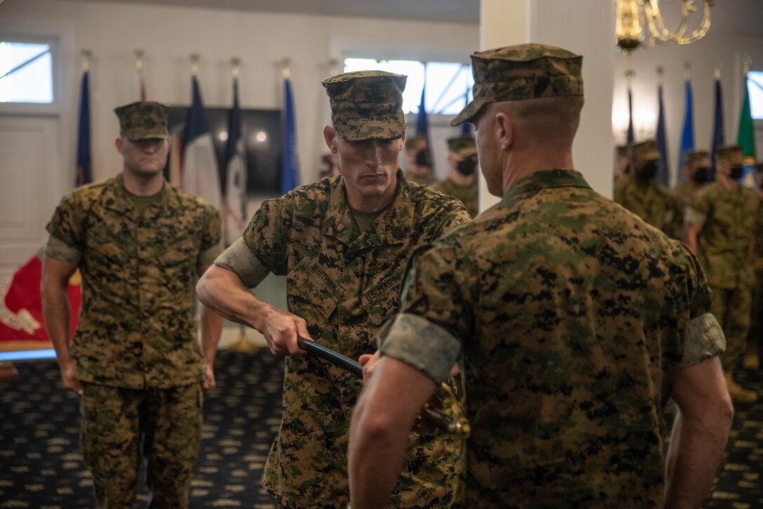 U.S. Marine Corps Sgt. Maj. Christopher J. Whitman, outgoing sergeant major of Combat Logistics Battalion 22 (CLB-22) passes the noncommissioned officer’s sword to Lt. Col. Luke A. Sauber, commanding officer, CLB-22, during a relief ceremony on Camp Lejeune, North Carolina July 27, 2021, 2021. Sgt. Maj. Christopher J. Whitman relinquished his duties as CLB-22’s sergeant major, a new sergeant major will be appointed at a later date. (U.S. Marine Corps photo by Lance Cpl. Zachary Zephir)