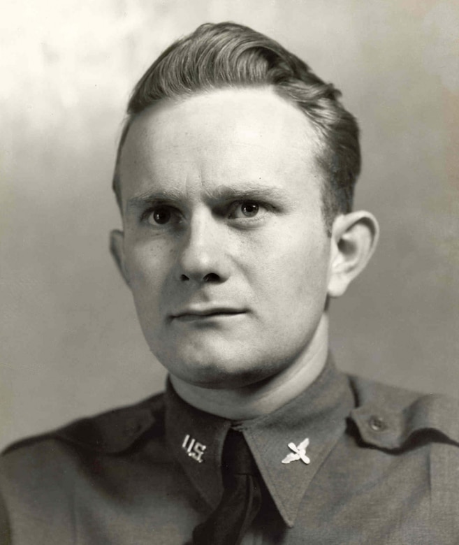 A man in a service jacket looks toward the camera.